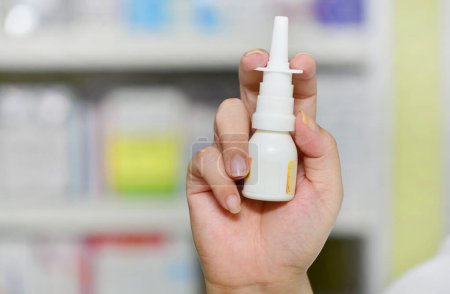 Photo for Close up shot pharmacist holding nasal spray medicine at the drugstore.Seasonal health issues - Royalty Free Image