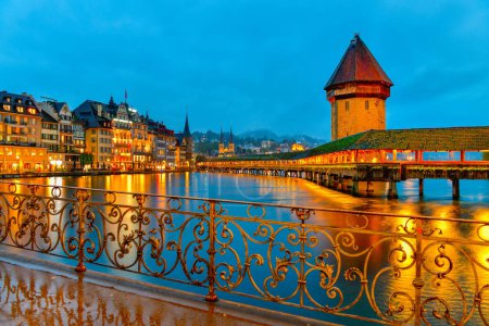 Hermosa ciudad histórica de Lucerna con el famoso puente de la capilla y la torre de agua en el crepúsculo, Suiza