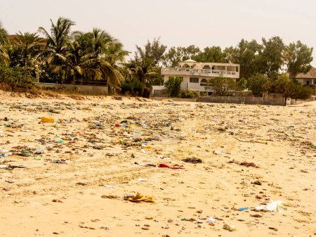 Photo for WARANG, MBOUR, SENEGAL - Circa JANUARY 20222. Beach sand of atlantic ocean with so many garbage plastic pollution in Senegal Africa. No place for tourism on beach to enjoy holidays - Royalty Free Image