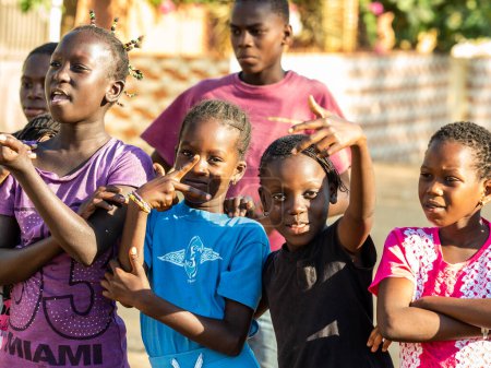 Foto de MBOUR, SENEGAL - CIRCA MARZO 2021. Grupo no identificado de niños y adolescentes africanos sonrientes felices mirando la cámara. - Imagen libre de derechos