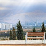 Park bench with view to Ashgabat. Dtamatic sky with sunbeams. , Turkmenistan