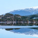 A breathtaking stock photo capturing the serene beauty of snow-capped mountains mirrored in the pristine waters of a tranquil lake. The perfect blend of natures grandeur and serene reflections, ideal