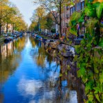 Amsterdam, Nedherlands- November 5, 2017: City center skyline with brick houses and boats. Famous landmark of old european city in autumn. 