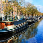 Amsterdam, Nedherlands- November 5, 2017: City center skyline with brick houses and boats. Famous landmark of old european city in autumn. 