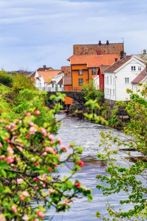 Traditionelle bunte Holzhäuser am Ufer des Flusses und schaffen eine malerische und charmante Atmosphäre. Sogndalstrand, Norwegen