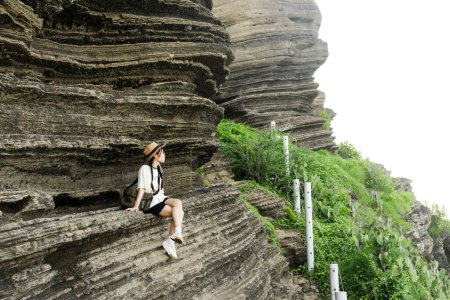 Foto de Imagen de una chica sentada en un majestuoso acantilado - Imagen libre de derechos