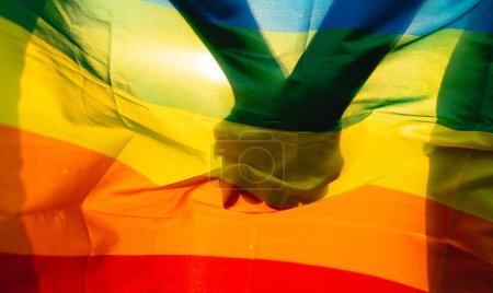 image of gay couple holding hands on lgbt flag