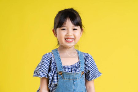 Foto de Retrato de una hermosa chica asiática, aislada sobre fondo amarillo - Imagen libre de derechos