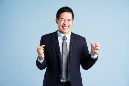 Photo for Portrait of asian businessman wearing suit on blue background - Royalty Free Image