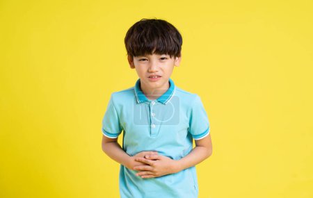 Photo for Portrait of an asian boy posing on a yellow background - Royalty Free Image