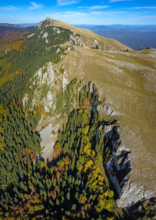 Foto de Vista aérea del avión no tripulado sobre el macizo Buila. Abismos rocosos agudos están protegiendo la meseta alta. Montañas Capatanii, Rumania.Forest crecen bajo los picos rocosos. - Imagen libre de derechos