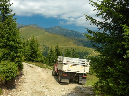 Driving an off road semi-truck on high altitude mountainous roads. The jeep reached the alpine grasslands after a trip through the coniferous forests Parang Mountains. Carpathia, Romania.