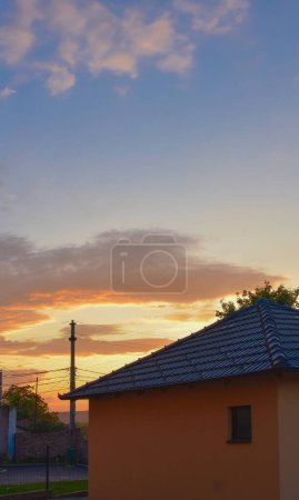 Photo for Sunset and flaming sky above the quiet courtyard of a small urban hous - Royalty Free Image