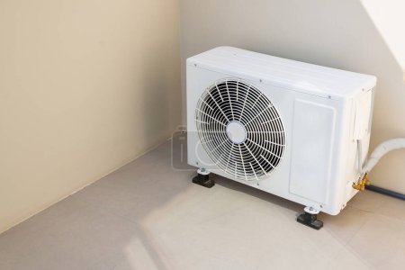 Téléchargez les photos : Installé à l'extérieur du mur de la maison est un compresseur pour le climatiseur extérieur. - en image libre de droit