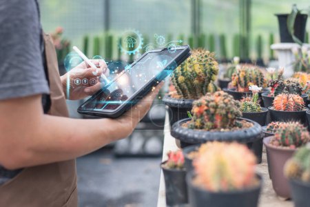A person uses a tablet to monitor cactus plants in a smart greenhouse with digital futuristic interface