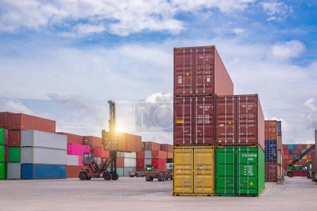 Cargo containers in various colors being stacked at a commercial shipping dock under a cloudy sky