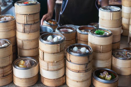 Stacks of bamboo steamers filled with a variety of dim sum dishes, ready for service in a traditional Chinese restaurant