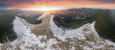 Auf einer Alm in den Karpaten, Ukraine, im Winter, Schafspfade im Schnee, Hirtenhäuser auf dem Berg sind gut sichtbar, die Morgenwolken ziehen schnell vorbei