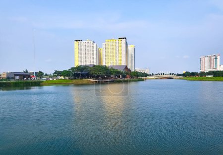 Téléchargez les photos : Bekasi, Indonésie Mars, 12 2023 Vue sur le lac dans le quartier central des affaires de BCBD Bekasi de Summarecon Bekasi, avec des bâtiments et un ciel bleu en arrière-plan - en image libre de droit