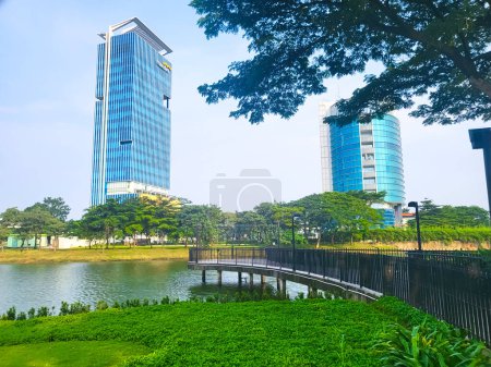 Téléchargez les photos : Bekasi, Indonésie - 12 mars 2023 Vue sur le lac dans le quartier central des affaires de BCBD Bekasi à Summarecon Bekasi, avec des bâtiments et un ciel bleu en arrière-plan - en image libre de droit