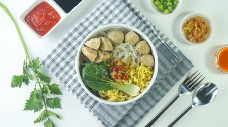 Téléchargez les photos : Boulette de viande, en Indonésie connue sous le nom de Bakso ou Baso. Servi avec des nouilles légumes sauce chili dans un bol sur fond blanc. Gros plan vue de dessus plat lay - en image libre de droit