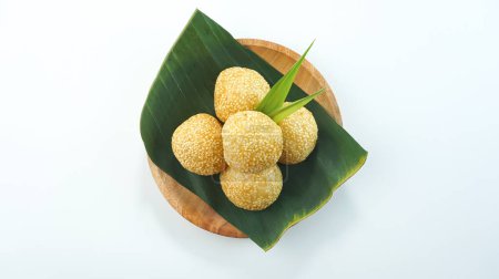 Téléchargez les photos : Boules de graines de sésame ou onde onde est un aliment traditionnel de l'Indonésie faite de farine de riz gluant haricots verts graines de sésame sucre brun servi dans une assiette isolée sur fond blanc vif. Vue du dessus - en image libre de droit