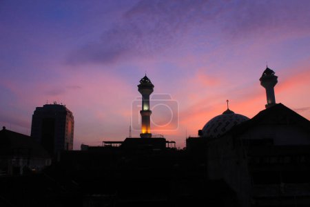 Téléchargez les photos : La silhouette de la Grande Mosquée Bandung avec le ciel orange et le soleil se lève comme arrière-plan - en image libre de droit