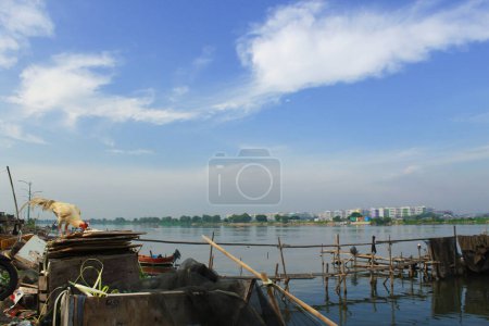 Téléchargez les photos : Bidonvilles riverains dans la ville de Jakarta, ciel bleu comme arrière-plan - en image libre de droit