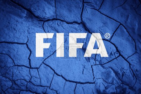 Téléchargez les photos : Drapeau de la FIFA. Symbole FIFA. Drapeau sur fond de terre fissurée sèche. FIFA Drapeau avec concept de sécheresse - en image libre de droit
