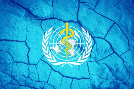 Téléchargez les photos : Flag of the WHO. World Health Organizationflag. UN symbol. Flag on the background of dry cracked earth.  WHO flag with drought concept - en image libre de droit