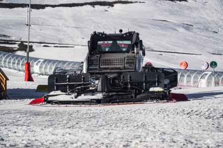 Téléchargez les photos : Huez, France - 9 avril 2023 : Snowcat, ratrack PistenBully - machine pour la préparation de la neige tout en travaillant dans l'Alpe D'huez - L'une des stations de ski les plus populaires dans les Alpes en France - en image libre de droit