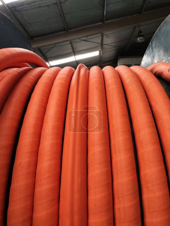 Photo for LSZH orange cable bending line in an iron bobbin with a slightly bumpy outer sheath. - Royalty Free Image