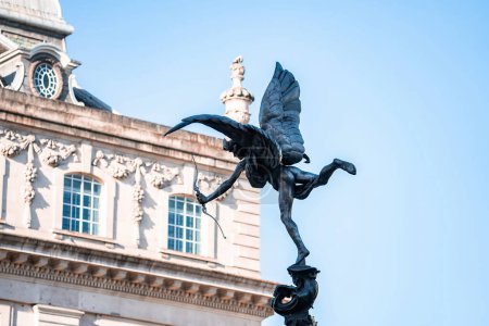 Téléchargez les photos : Statue d'Eros, Piccadilly Circus, Londres. Le point de repère familier placé contre un ciel bleu d'été avec espace de copie. - en image libre de droit
