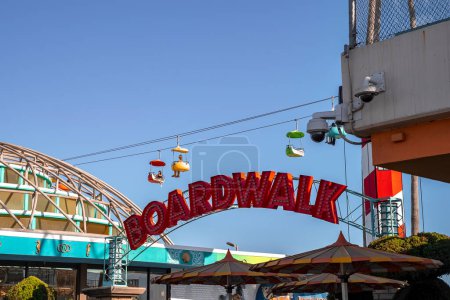 Photo for Santa Cruz, USA. September 20, 2022. Low angle view of red boardwalk text on entrance of amusement park at Santa Cruz Beach Boardwalk with sky glider in the background - Royalty Free Image