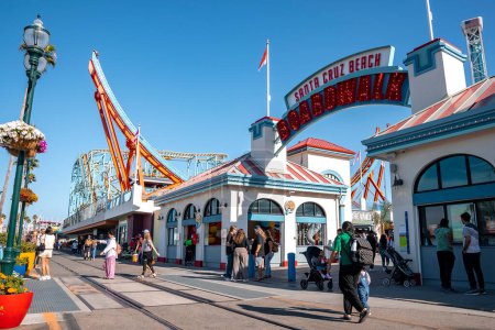 Photo for Santa Cruz, USA. September 20, 2022. People on street and entrance of amusement park with Santa Cruz Beach Boardwalk sign under clear blue sky during sunny day - Royalty Free Image