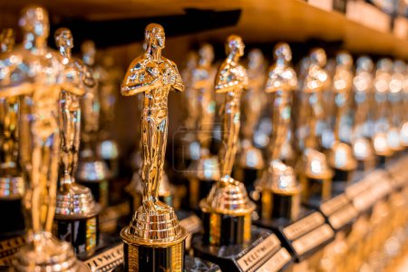 Photo for Close-up of artificial Hollywood golden oscar academy trophies arranged in a row on shelf for sale in store at Los Angeles - Royalty Free Image
