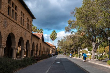 Photo for Palo Alto, USA. September 20, 2022. Diminishing perspective of street by historical Stanford University and trees growing under cloudy sky at California - Royalty Free Image