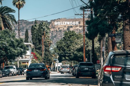 Foto de Los Ángeles, Estados Unidos. 20 de septiembre de 2022. Coches moviéndose en la carretera en medio de árboles que conducen hacia el hermoso Monte Lee con el cartel de Hollywood en el día soleado con el cielo despejado en el fondo - Imagen libre de derechos