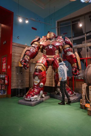 Photo for Young man standing next to the Hulk Buster Iron Man costume at The Madame Tussauds museum in Las Vegas, USA. - Royalty Free Image