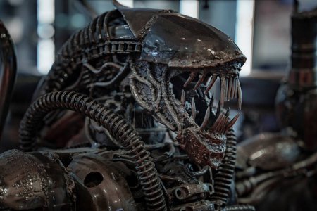 Photo for Slightly dusty xenomorph Alien statue by Eaglemoss collections on black background, designed by Hans Rudolf Giger for the 1979 film - Royalty Free Image