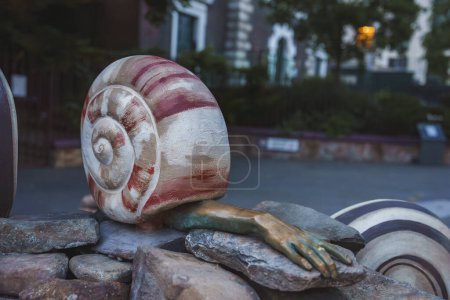 Photo for The half human sculpture depict human body parts extending from the shells of snail and molluscs. Earthling artworks by Jocelyn McGregors In London at Aldgate square - Royalty Free Image