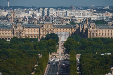 Photo for Aerial view of the Louvre and its pyramid in Paris on a sunny day, showcasing its vast size and green surroundings. - Royalty Free Image