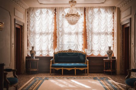 Téléchargez les photos : Élégante chambre avec un superbe lustre et un luxueux canapé bleu. Parfait pour l'inspiration de design d'intérieur. - en image libre de droit