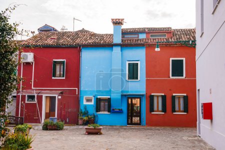 Téléchargez les photos : Explorez les charmantes rues de Burano, en Italie, avec cette photographie animée présentant des maisons vénitiennes traditionnelles dans des tons vifs de bleu, vert, rose et jaune. - en image libre de droit