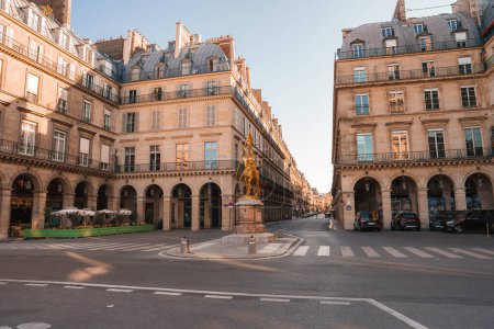 Téléchargez les photos : Vue matinale ensoleillée d'une rue urbaine vide avec des bâtiments de style Renaissance beige et le monument Jeanne dArc. - en image libre de droit