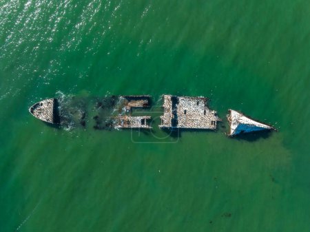 Foto de Un viejo buque cisterna naufragó cerca de la costa de California, EE.UU. Ahora hogar de muchas aves como pelícanos y gaviotas marinas. Vista aérea de naufragio del barco. - Imagen libre de derechos