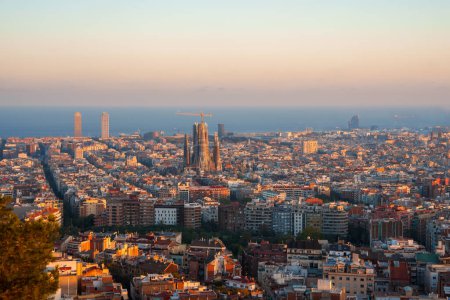 Téléchargez les photos : Vue panoramique de Barcelone au lever ou au coucher du soleil avec une lumière dorée sur le paysage urbain, avec la Sagrada Familia et des gratte-ciel de premier plan comme Torre Glories et Hotel Arts. - en image libre de droit