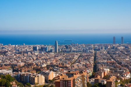 Téléchargez les photos : Vue panoramique du quartier de Barcelonas Eixample sous un ciel dégagé, mettant en valeur le réseau urbain, les gloires de Torre et les toits côtiers près du port olympique. - en image libre de droit
