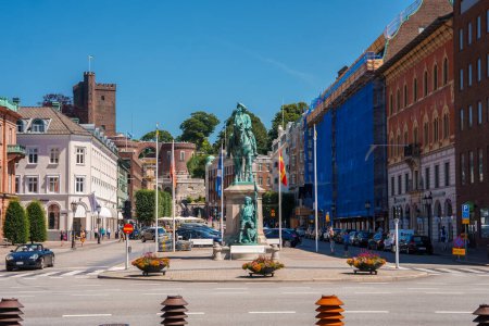 Photo for A sunny urban square with a central statue wielding a sword, surrounded by Europeanstyle buildings and ongoing renovations, lined with flags and flowers, in Helsingborg. - Royalty Free Image
