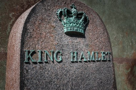 Téléchargez les photos : Gros plan d'un monument en granit avec le ROI HAMLET et une couronne détaillée, commémorant probablement une figure royale, peut-être à Helsingborg, avec un fond flou. - en image libre de droit